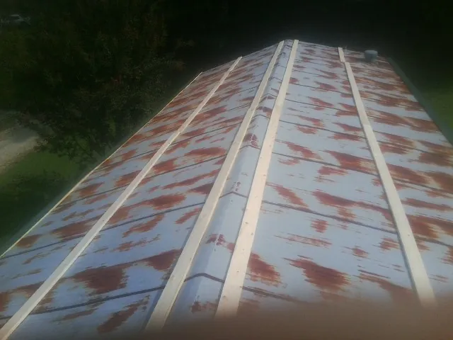 Rusted metal roof panels with new wood purlins before replacement — Storm Damage Roof Repair in Haines by Roofing Brothers