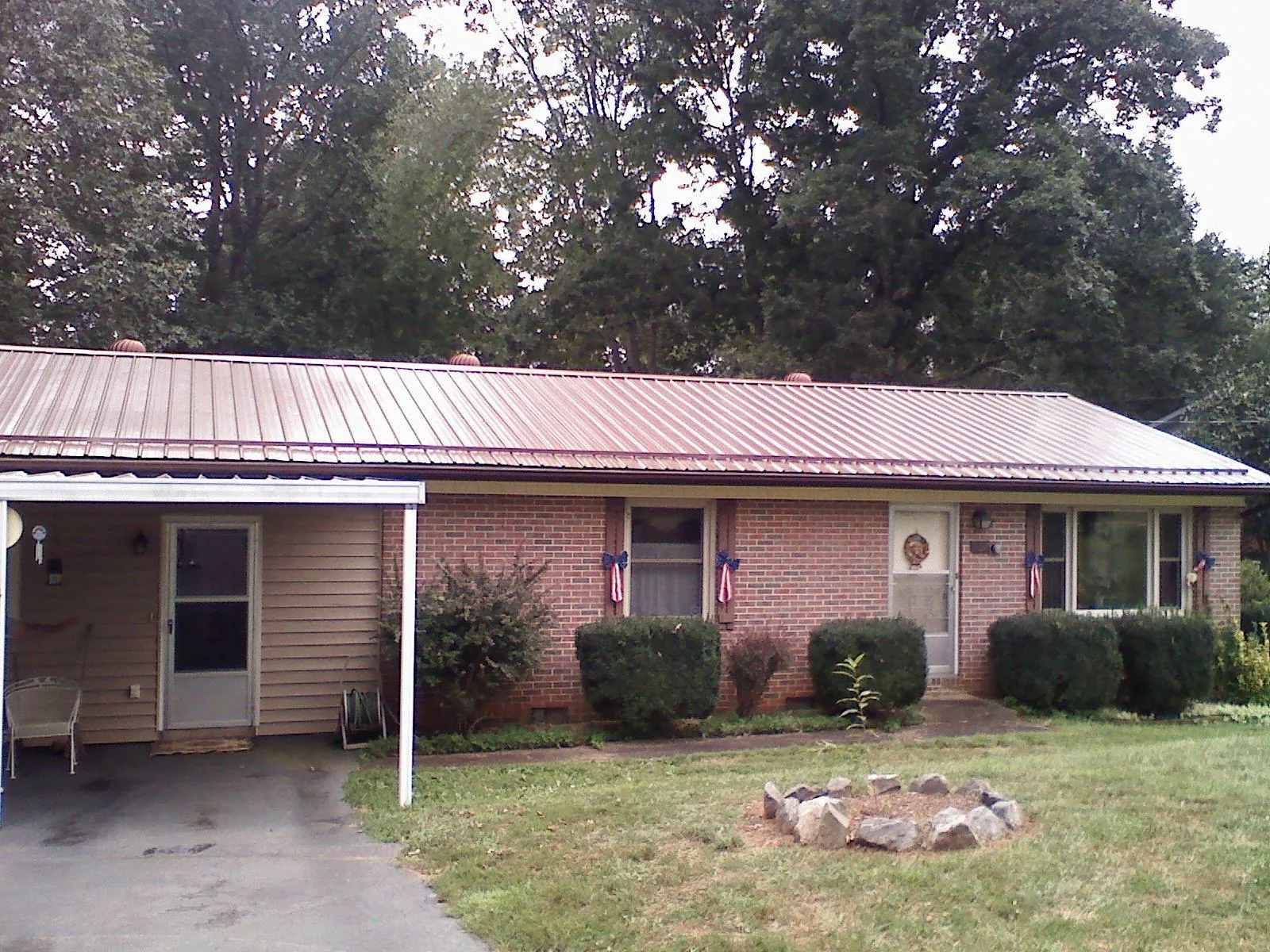 Bronze metal roof and carport on a brick ranch home — Roof Repair work by our crew in Haines