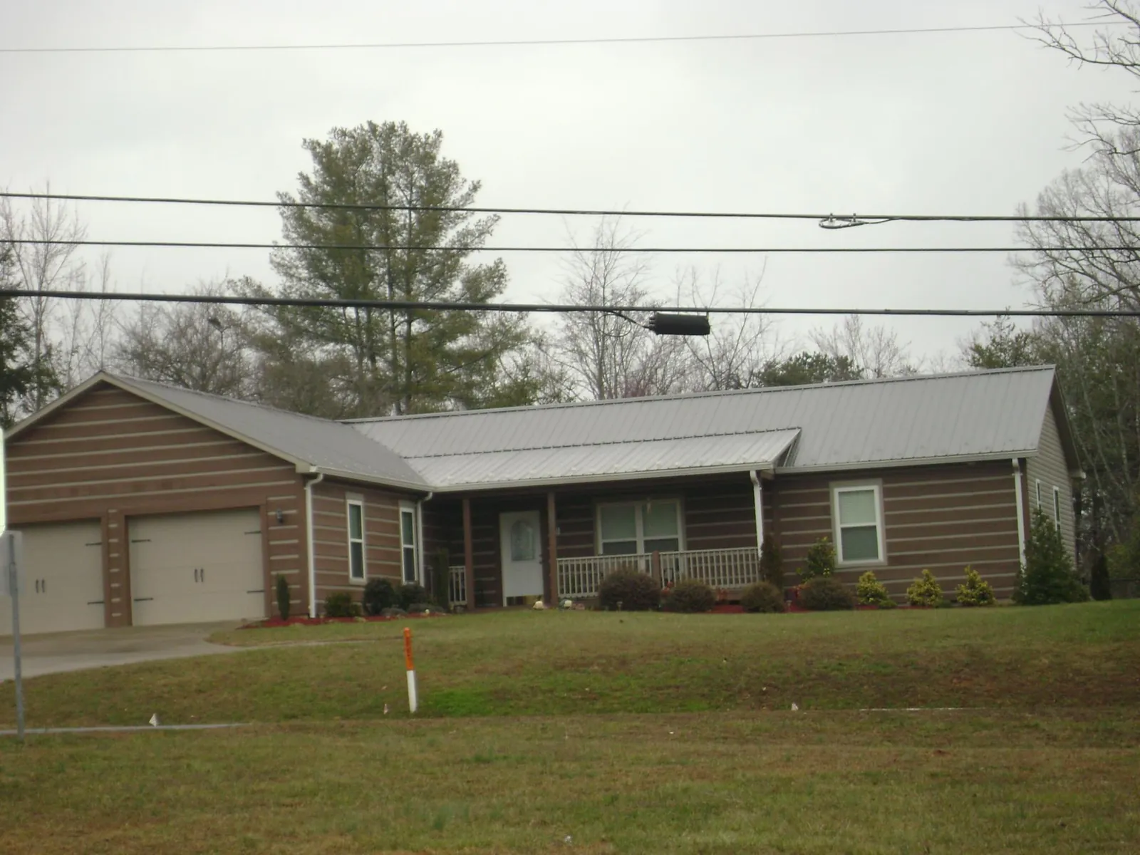 Gray metal roof on a log sided ranch home with a front porch in Haines